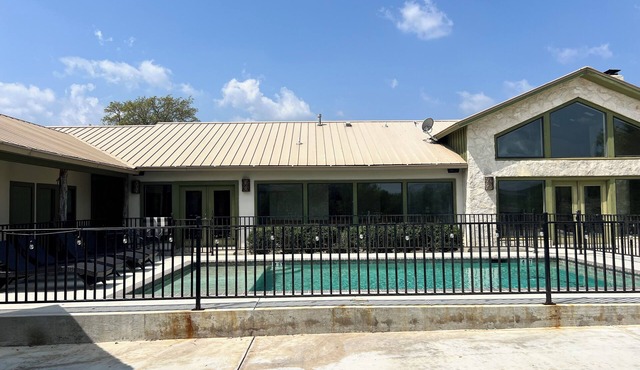 Large home with a pool sitting on the tee of the first tee box in Concan